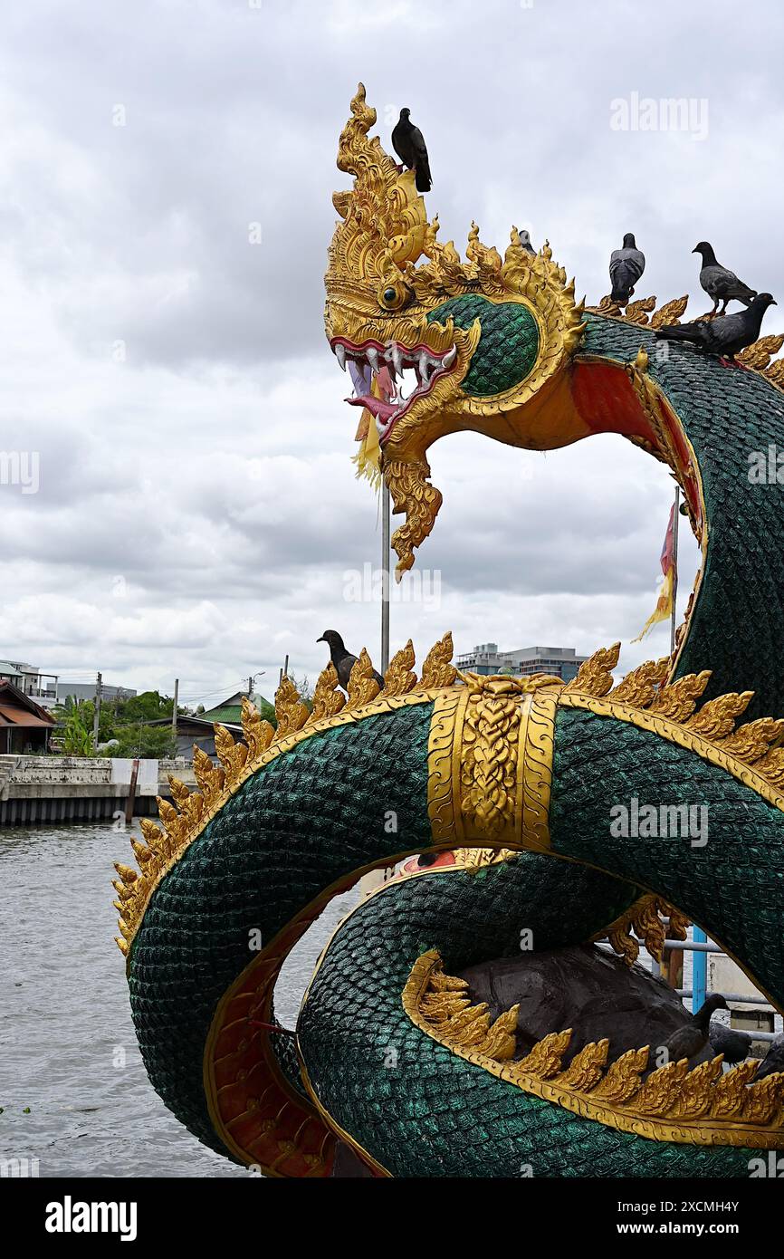 Nahaufnahme einer Naga-Skulptur mit Blick auf einen Wasserkanal in Thailand Stockfoto