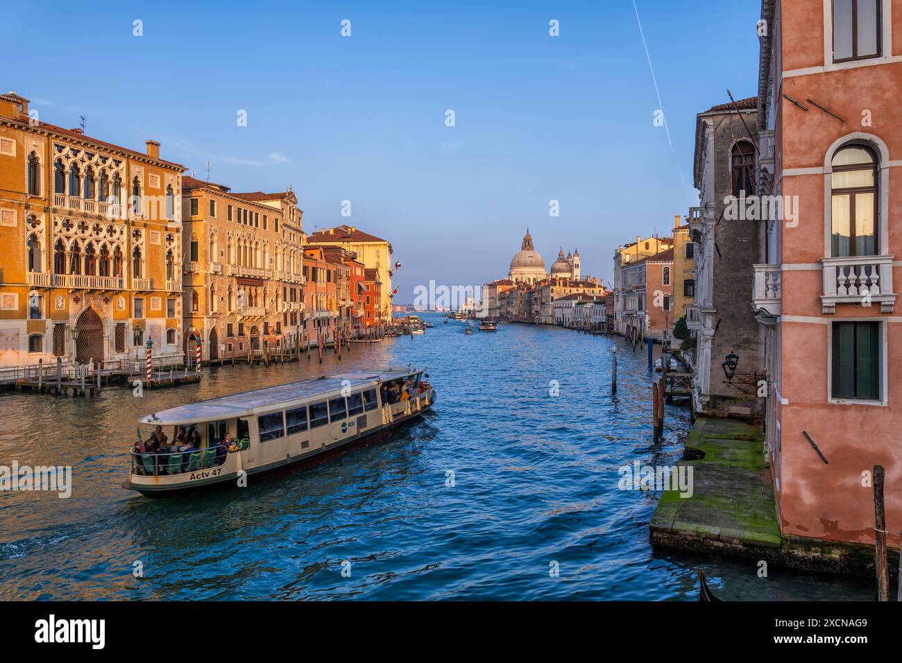 Stadt Venedig bei Sonnenuntergang in Italien. Der Canal Grande zum Ende mit dem Wasserbus zwischen den Vierteln San Marco und Dorsoduro, Blick von der Accademia Bridg Stockfoto