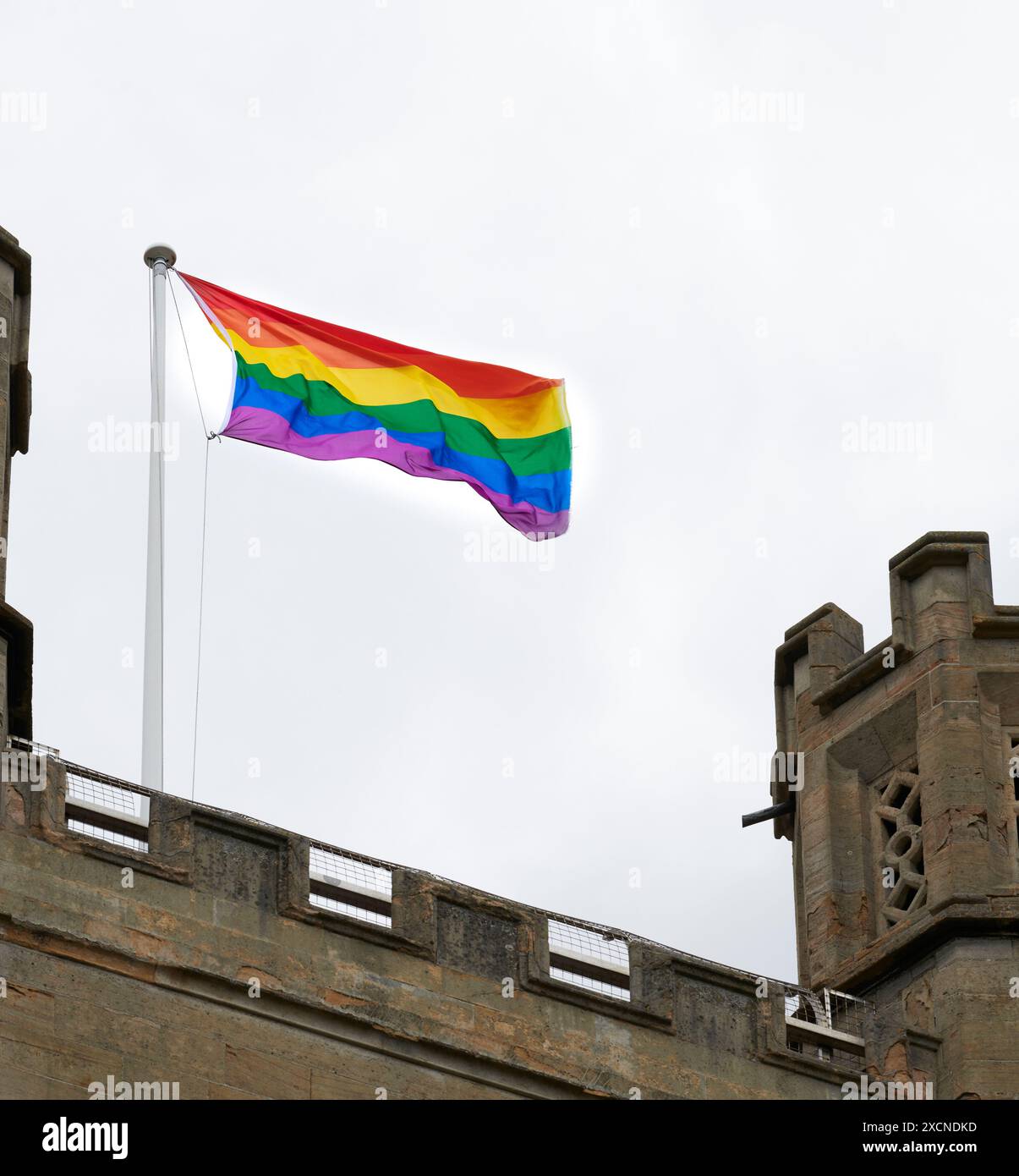 Zwei Schwulen- und Trans-Fahnen flattern vom Turm der St. Mary the Great Church, University of Cambridge, England. Stockfoto