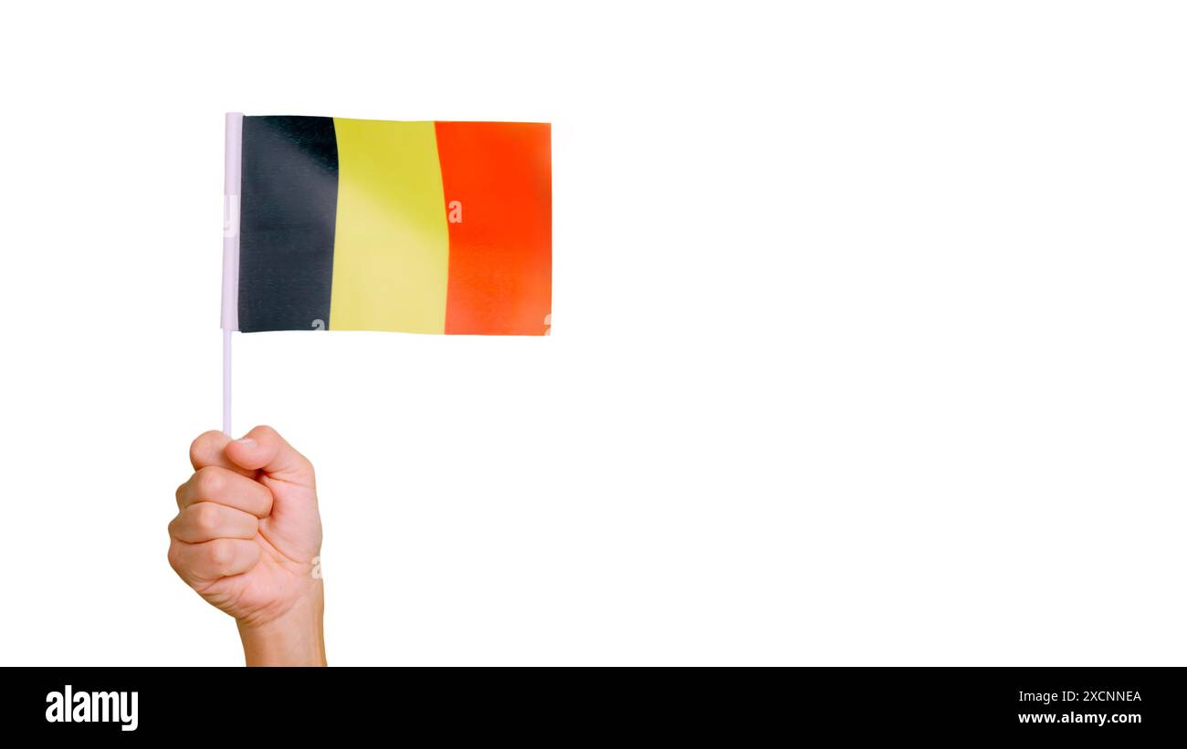 Wind winkt einen belgischen Wimpel, der von einer Person gehalten wird Stockfoto