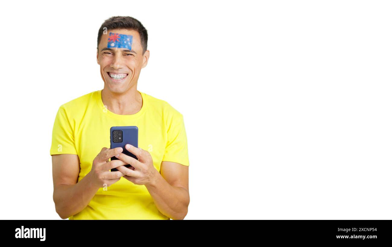 Australischer Unterstützer, der sein Handy lächelnd ansieht und es zeigt. Stockfoto
