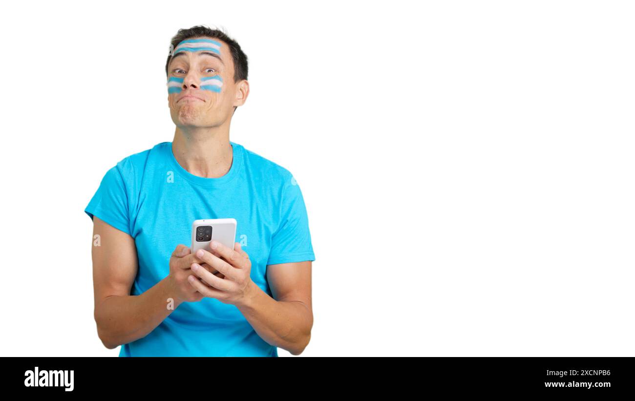 Argentinien-Unterstützer, der sein Handy lächelnd ansieht und es zeigt. Stockfoto