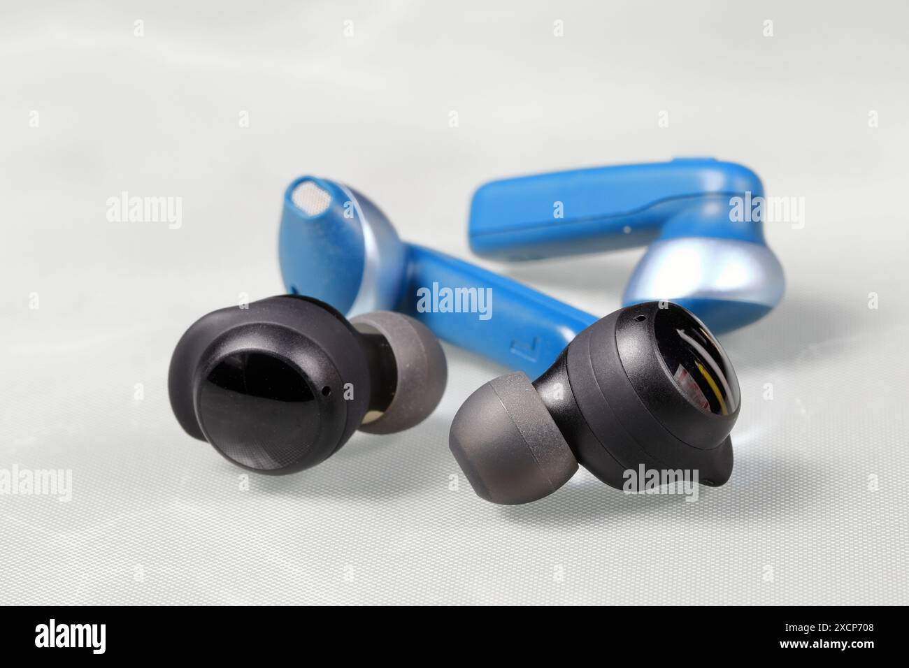 Schwarzer und blauer bluetooth kabelloser Ohrhörer oder Ohrhörer oder Kopfhörer, isoliert auf weißem Hintergrund. Stockfoto