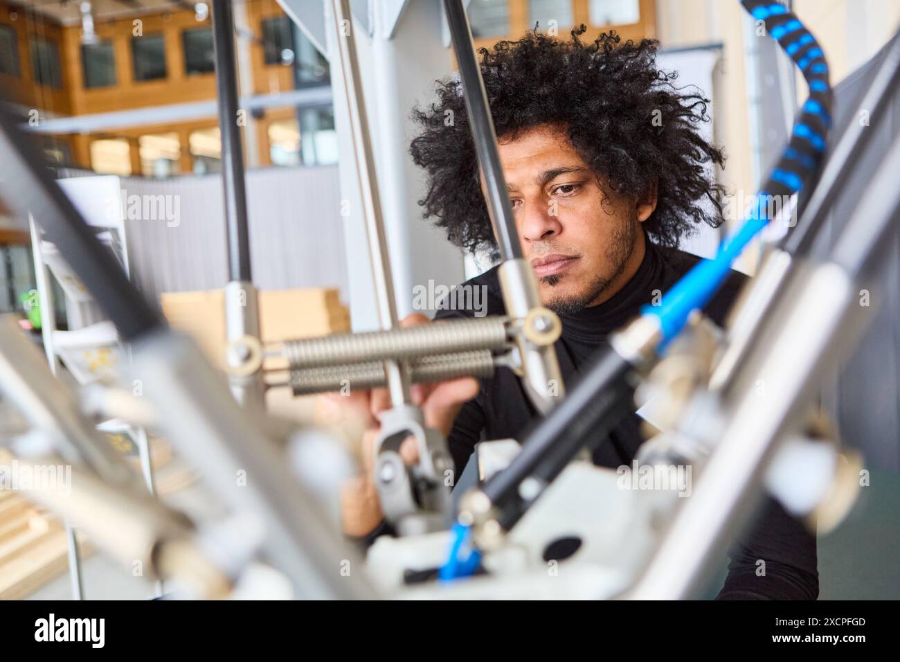 Fokussierter Ingenieur, der einen Robotergreifer in einer modernen Werkstatt optimiert. Entwicklung von Industrierobotik und Automatisierung. Stockfoto