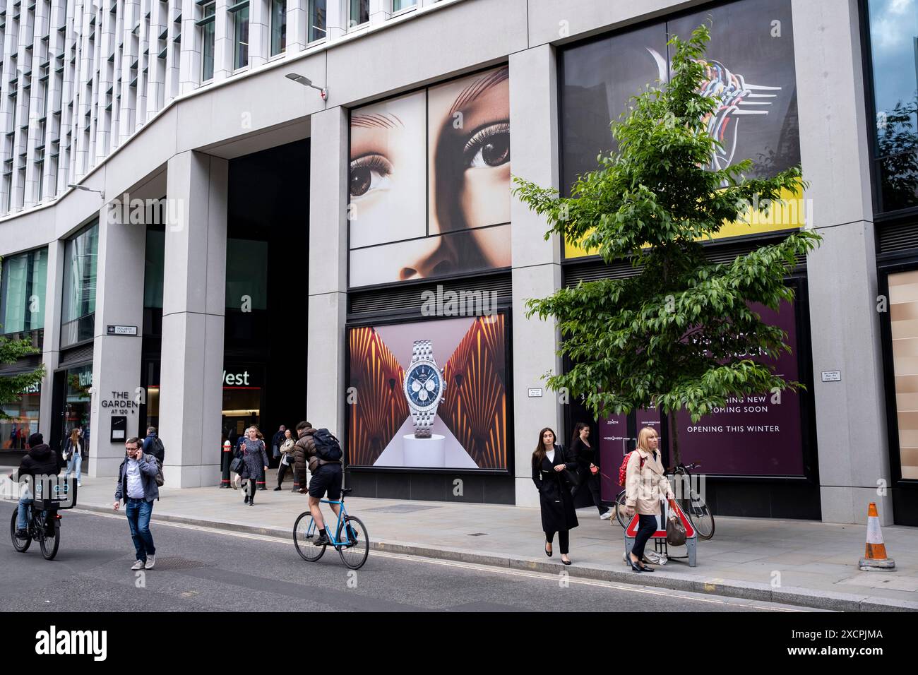 Passanten interagieren mit einem riesigen Gesicht mit Blick auf die Fenchurch Street über einem großformatigen Werbeplakat für die Luxusuhrenmarke Breitling in der City of London am 11. Juni 2024 in London, Großbritannien. Die Atmosphäre besteht darin, dass man beobachtet wird und dass Big Brother Sie beobachtet. Die City of London ist eine Stadt, ein zeremonielles County und ein lokaler Regierungsbezirk, der den Hauptgeschäftsbezirk von London umfasst. Die City of London wird allgemein als „Square Mile“ bezeichnet. Stockfoto
