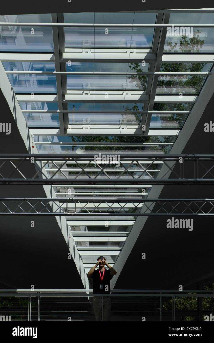 Magdeburg, Deutschland. Juni 2024. Ein Mann steht in der Hyparschale unter den Fenstern der selbsttragenden Dachkonstruktion und macht Fotos. Die Renovierung der Hyparschale steht kurz vor dem Abschluss. Ab 1. Juli 2024 wird die Messe- und Veranstaltungsgesellschaft Magdeburg die modernisierte Veranstaltungshalle betreiben. Die Stadt Magdeburg investierte rund 24,8 Millionen Euro in die Renovierung. Quelle: Klaus-Dietmar Gabbert/dpa/Alamy Live News Stockfoto