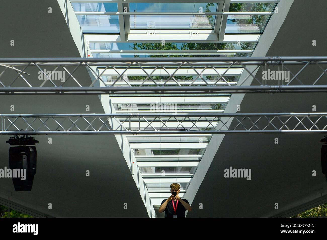 Magdeburg, Deutschland. Juni 2024. Ein Mann steht in der Hyparschale unter den Fenstern der selbsttragenden Dachkonstruktion und macht Fotos. Die Renovierung der Hyparschale steht kurz vor dem Abschluss. Ab 1. Juli 2024 wird die Messe- und Veranstaltungsgesellschaft Magdeburg die modernisierte Veranstaltungshalle betreiben. Die Stadt Magdeburg investierte rund 24,8 Millionen Euro in die Renovierung. Quelle: Klaus-Dietmar Gabbert/dpa/Alamy Live News Stockfoto