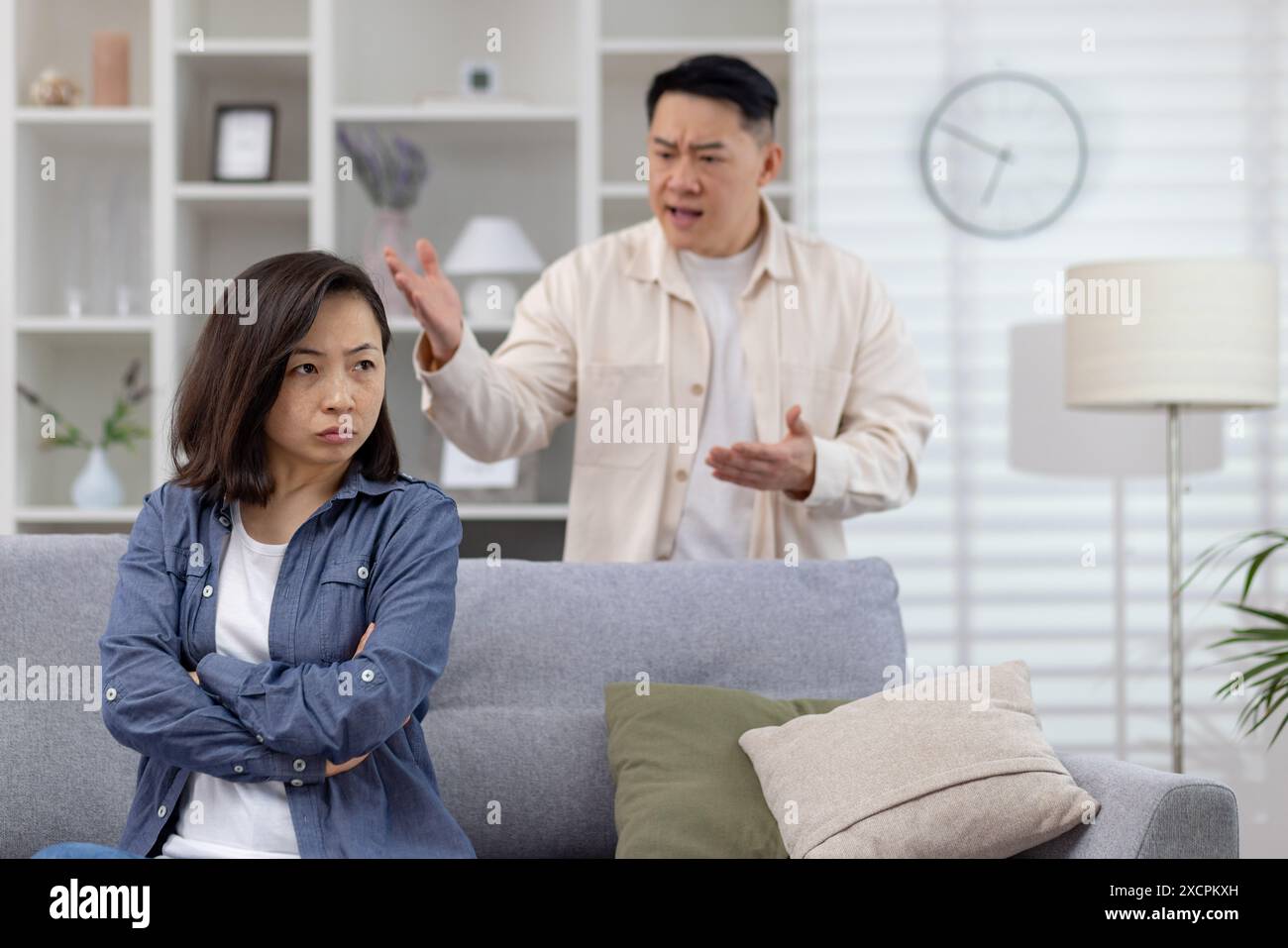 Junge asiatische Paare, Mann und Frau sind zu Hause und streiten, Mann begeht häusliche Gewalt und Missbrauch gegen Frauen. Stockfoto