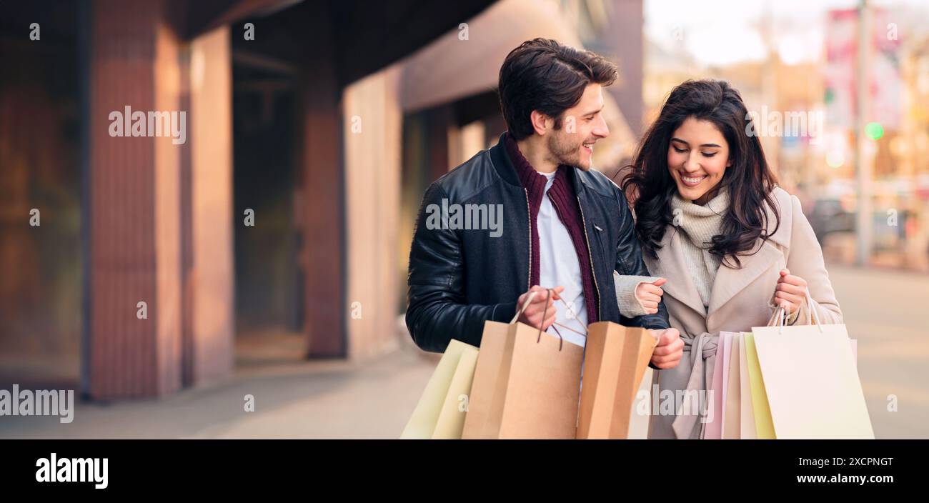 Junge shopaholics Suchen in Einkaufstaschen im Freien Stockfoto