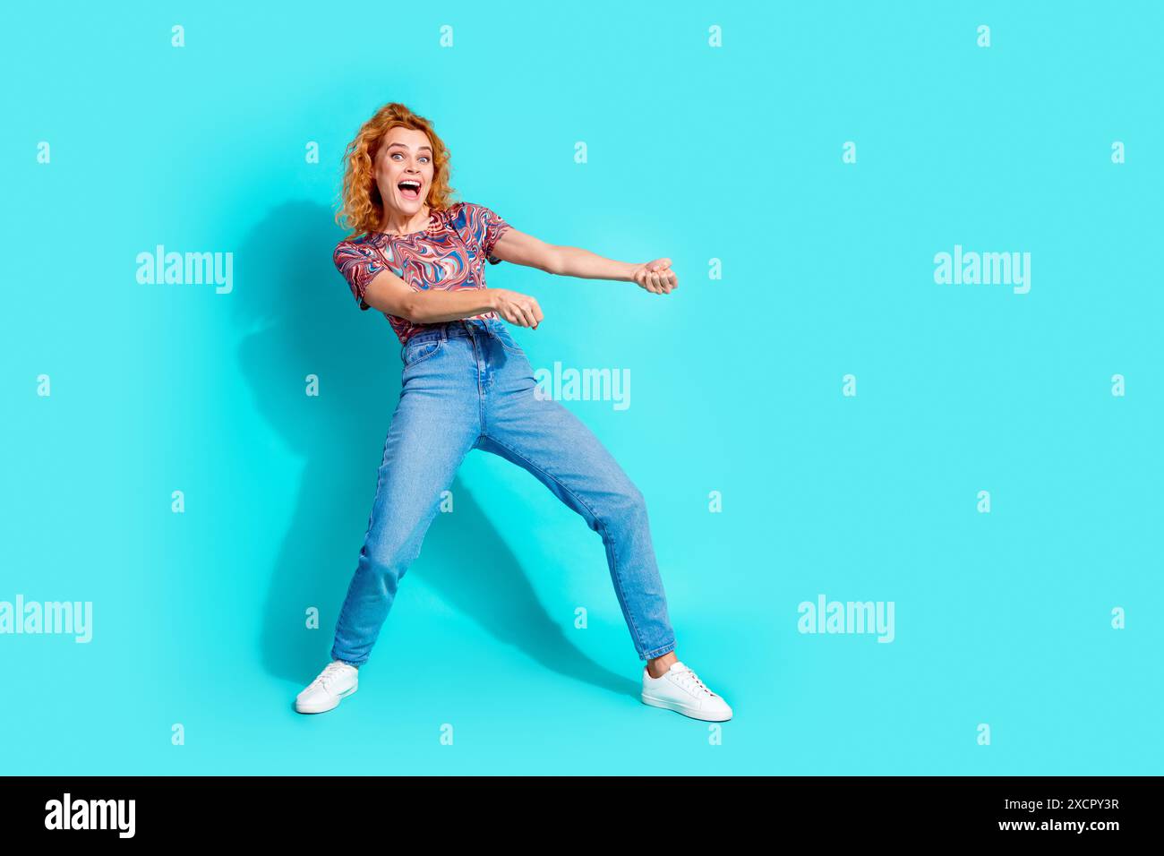 Porträt der netten Dame ziehen leeren Raum Seil tragen T-Shirt isoliert auf blauem Hintergrund Stockfoto