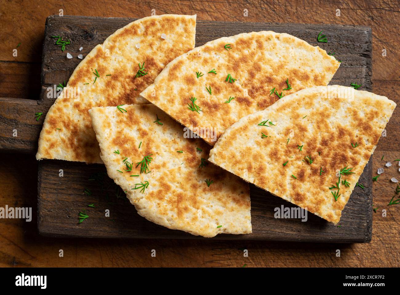 Pita-Brot auf hölzernem Hintergrund, Blick von oben. Georgianische oder arabische Küche. Türkisches Essen. Frisches hausgemachtes Naan-Fladenbrot. Traditionelles mediterranes Frühstück Stockfoto