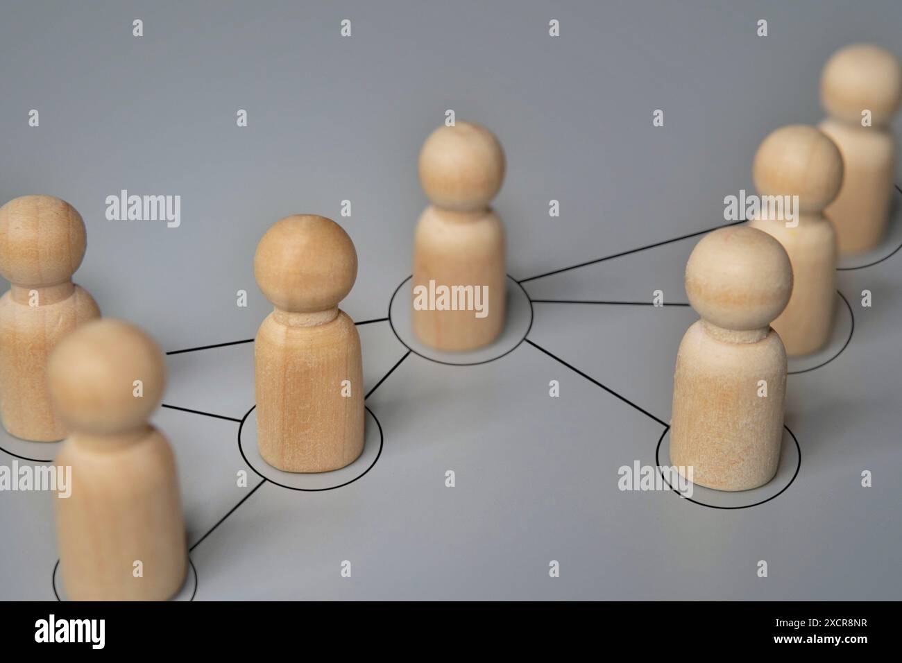 Holzpuppen, die durch Linien verbunden sind. Zusammenarbeit und Interaktion, Verbreitung von Informationen, Gerüchten Konzept. Stockfoto