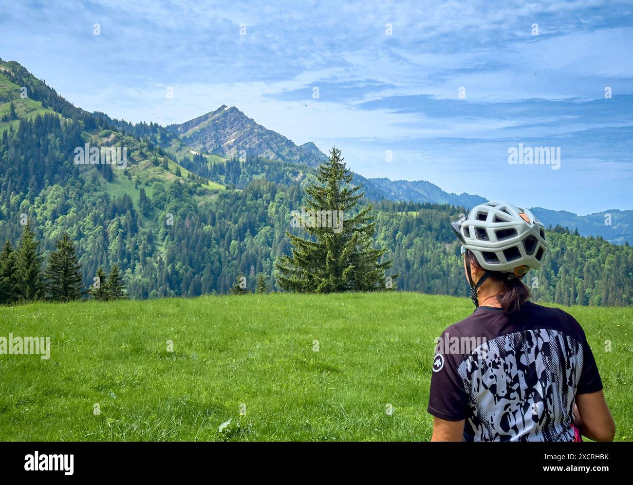 Hübsche Seniorin, die ihr E-Mountainbike auf den Bergen oberhalb Oberstaufens fährt, mit Nagelfluh-Bergkette im Hintergrund, Allgauer Alpen, BAV Stockfoto