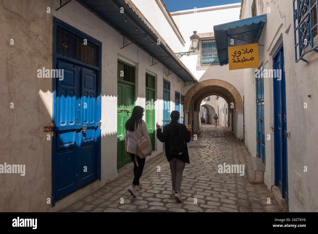 Tunis, Tunesien. Mai 2024. Zwei junge tunesische Frauen spazieren durch die traditionell geschmückten engen Gassen von Tunis Medina. (Foto: John Wreford/SOPA Images/SIPA USA) Credit: SIPA USA/Alamy Live News Stockfoto