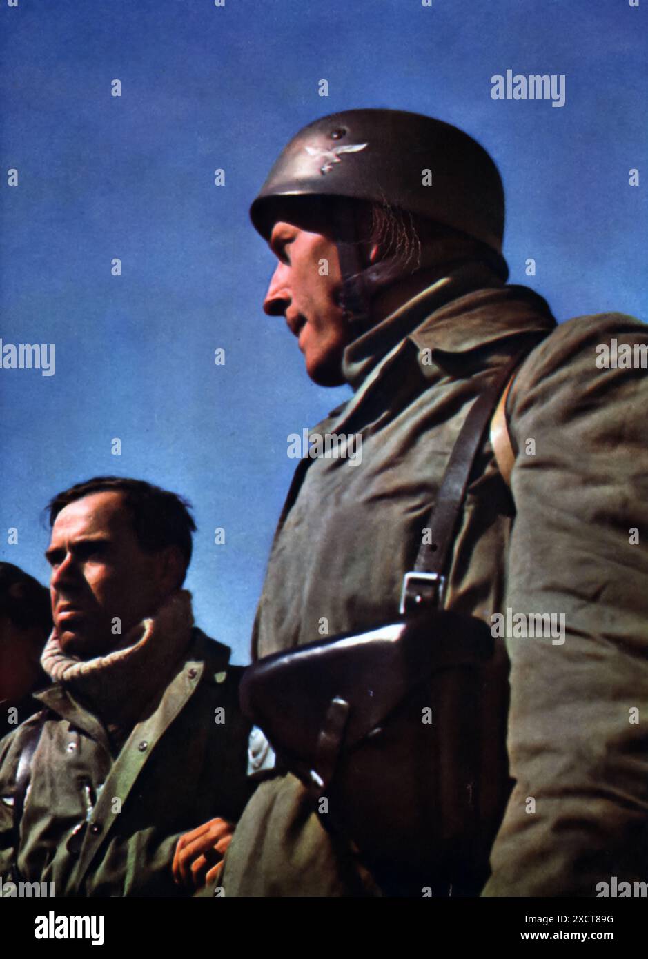 Ein Foto zeigt deutsche Soldaten, die nach einer Mission während des Zweiten Weltkriegs ruhten. Die Szene zeigt, wie erschöpft und erhitzt nach intensiven Operationen sind. Diese Soldaten, die Teil der Bodenstreitkräfte der Luftwaffe waren, spielten eine wichtige Rolle bei der Sicherung strategischer Positionen und der Aufrechterhaltung der Kontrolle über die eroberten Gebiete. Stockfoto