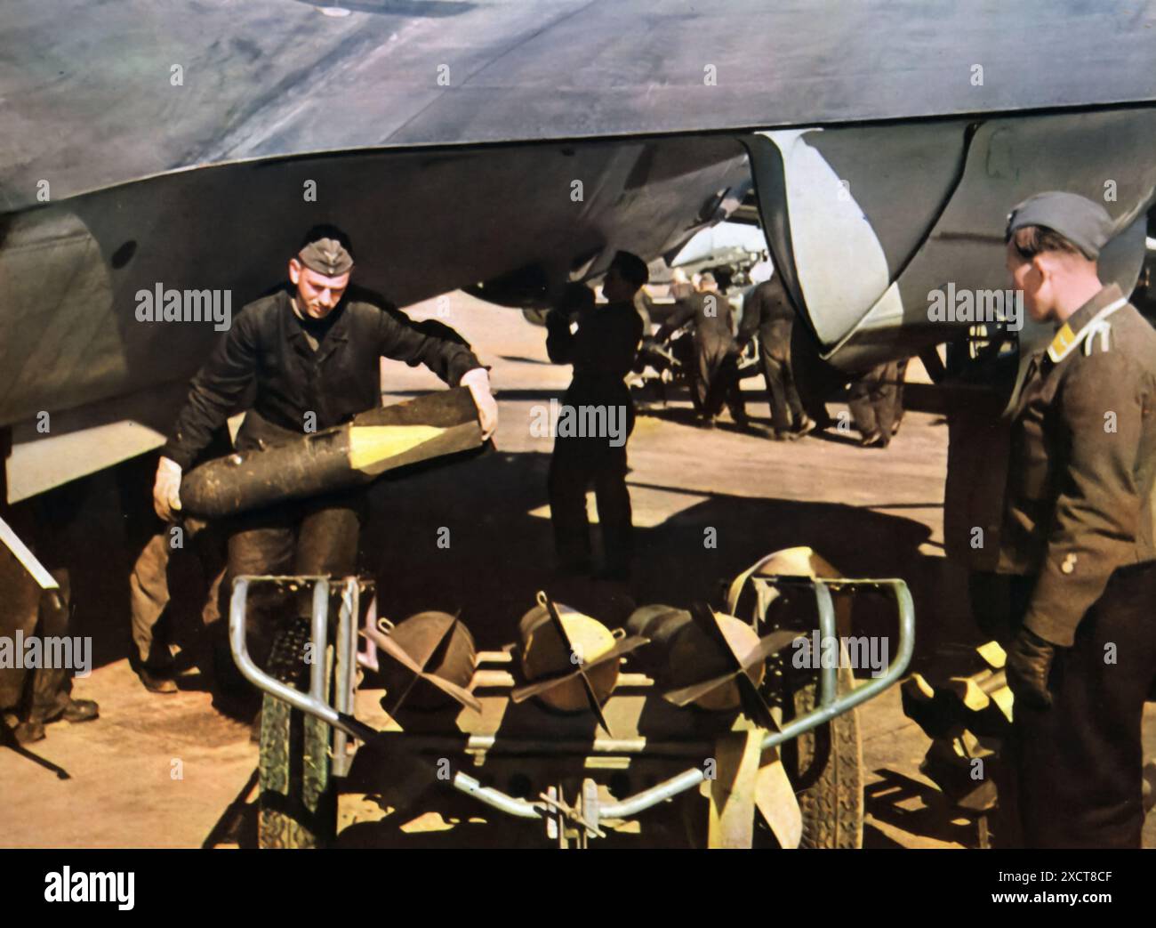 Ein Foto zeigt einen Luftwaffenbombentechniker, der vor einem Flug während des Zweiten Weltkriegs Munition inspiziert. Als Teil der deutschen Luftwaffe spielten diese Techniker eine entscheidende Rolle bei der Vorbereitung und Wartung der Bomben. Stockfoto