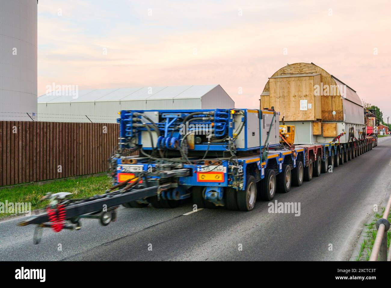 Sehr langer spezialisierter mehrachsiger Lkw-Anhänger trägt sehr schwere Übergröße-Übertragungsnetzwerk, statischer synchroner Kompensator, Rückansicht Stockfoto