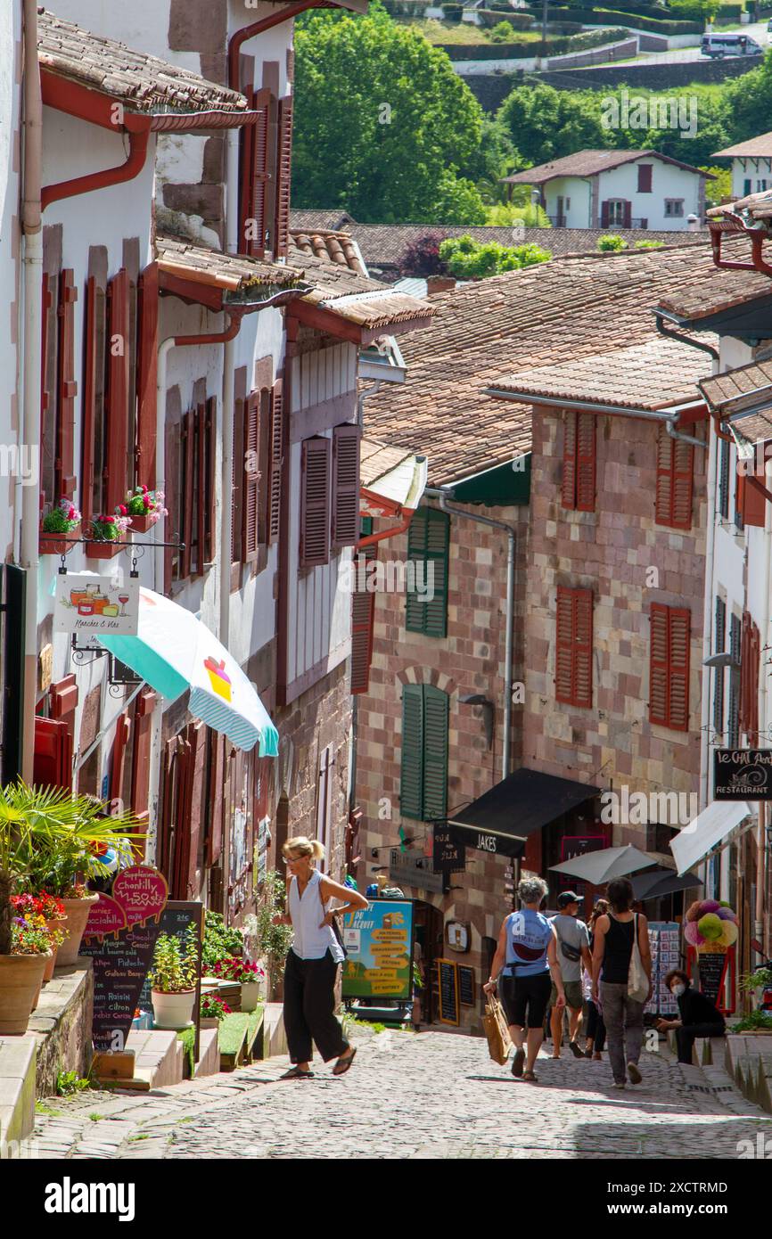 Touristen, die durch die Kopfsteinpflasterstraßen von Saint-Jean-Pied-de-Port laufen, dem modernen Beginn des Jakobsweges Stockfoto