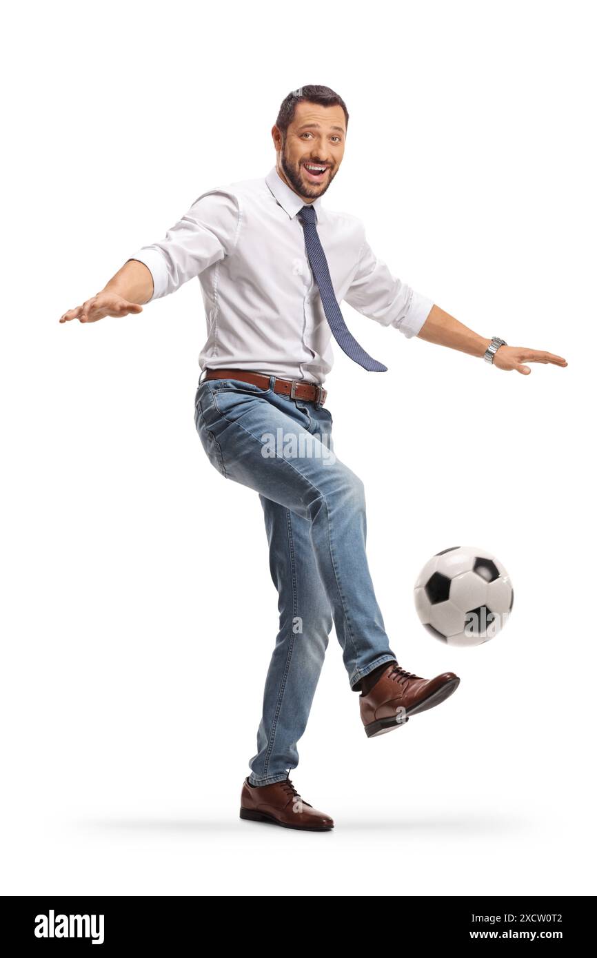 Ein Mann, der einen Football tritt und auf weißem Hintergrund lächelt Stockfoto