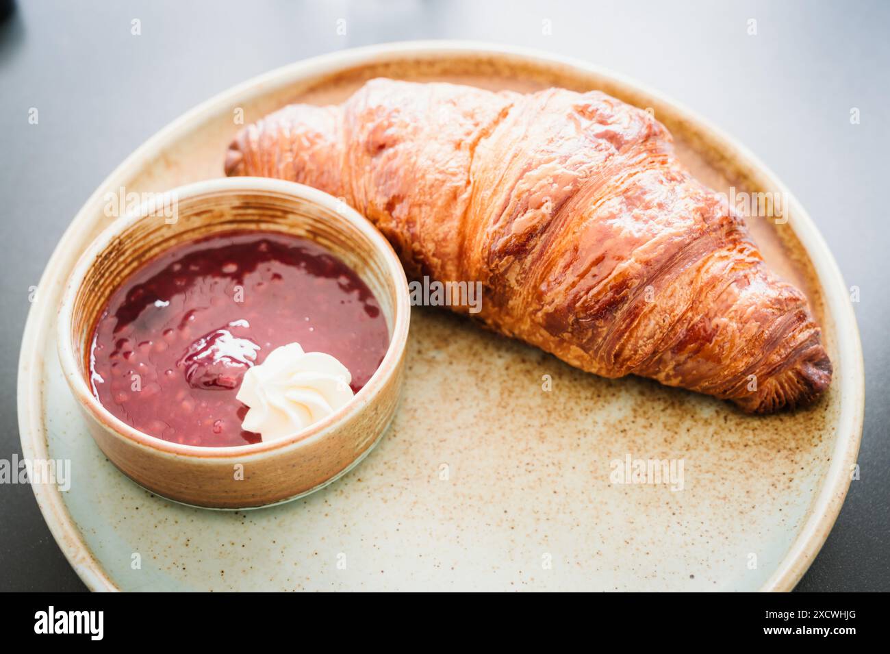 Ein Croissant mit Butter und hausgemachter Marmelade. Stockfoto