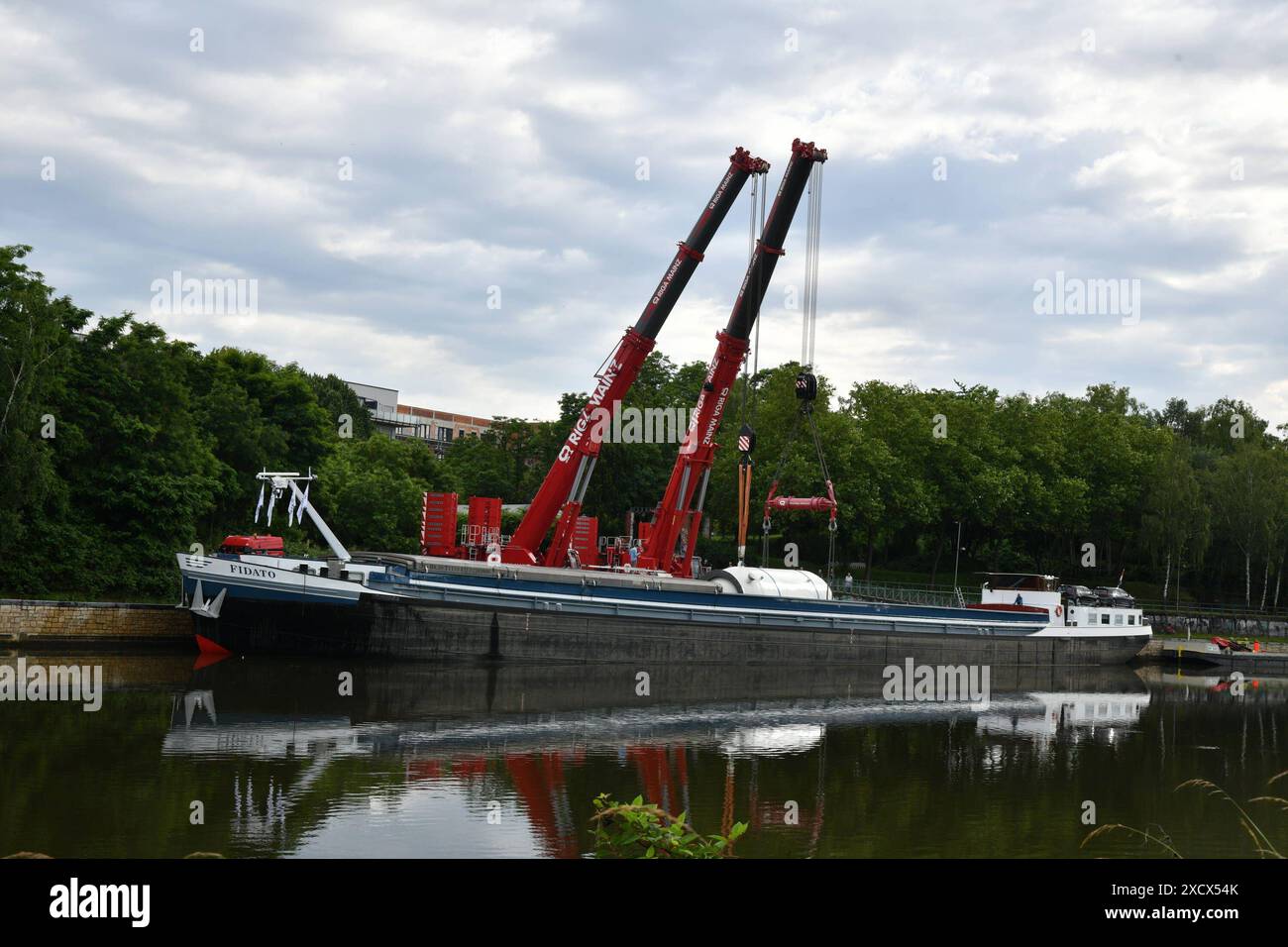 Ein Hochdruck-Gasabscheider, den die Firma Leffer i8n Dudweiler gebaut hat, wird am Dienstag 18.6.2024 an der Roro-Verladestelle der Saar in Saarbrücken mit Schwerlastkränen in einem Schiff gehoben. Die 175,85 Tonnen schwere Anlage wird nach Norwegen verschifft und lag mehrere Tage an der Saar wir berichteten. Das saarländische Familienunternehmen Leffer aus Dudweiler, ein Weltkonzern für den Stahl- und Apparatebau, hat den Abscheider mit einem Schwertransport zur Saar gebracht, jetzt geht es es es über Wasserstraßen weiter zum Ziel. Der Reaktor war mehrere Tage bewacht worden, um Vandalismus zu verhi Stockfoto