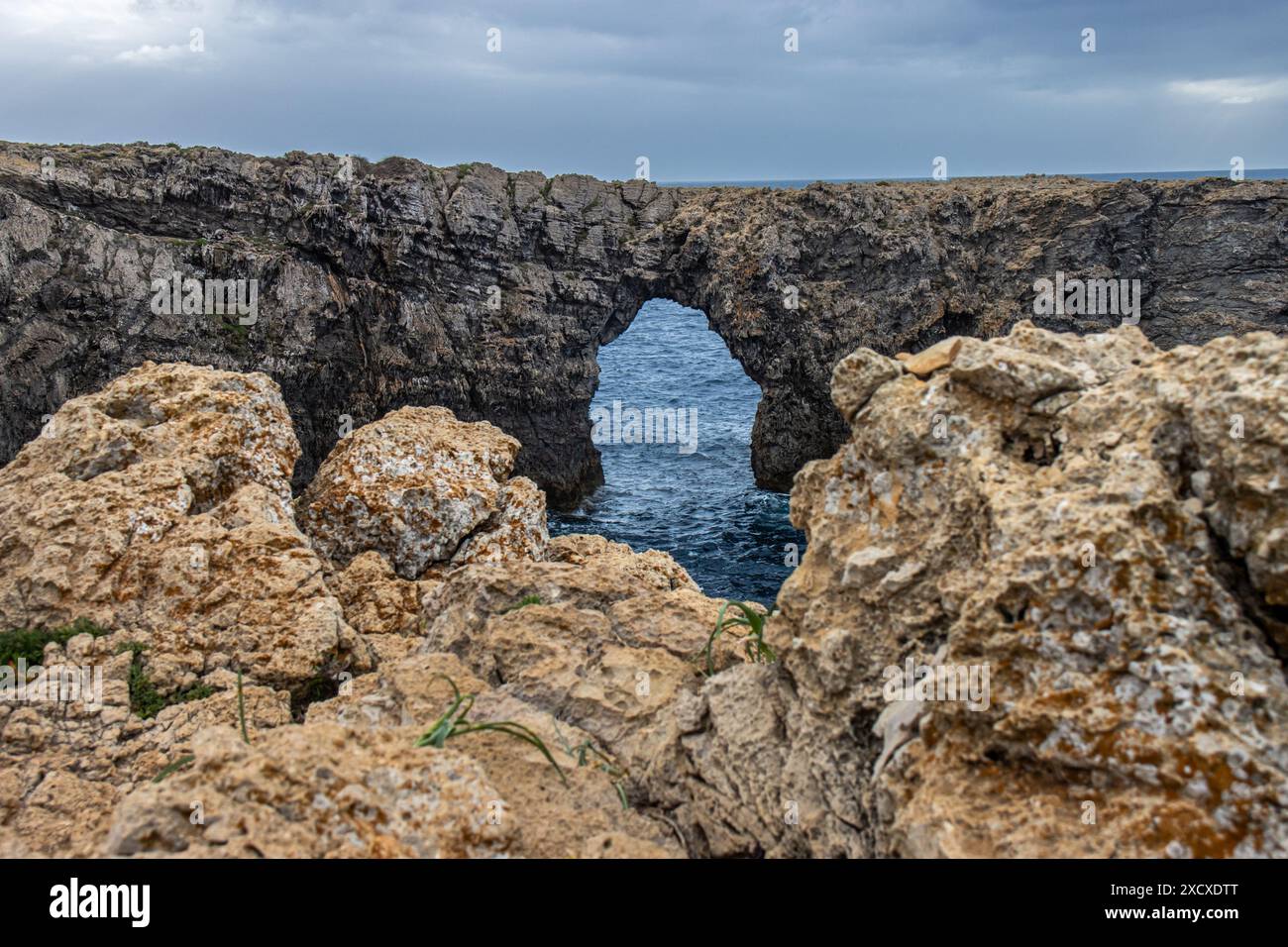 Pont de Gil, histórico puente de piedra que salva un barranco. Puente, naturaleza y horizonte marino crean una imagen de armonía. Menorca, España Stockfoto