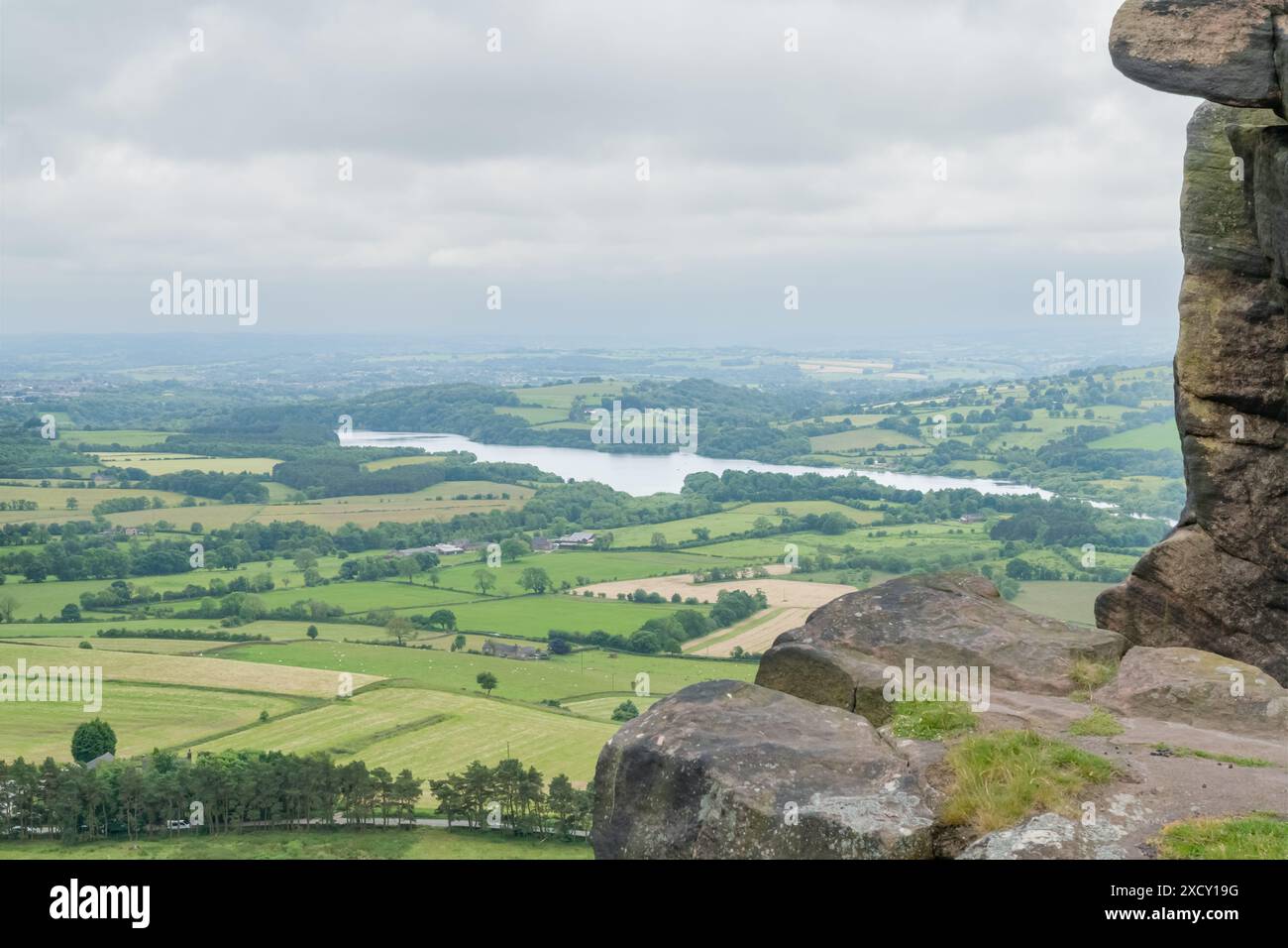 Blick vom Hen Cloud im Peak District, Großbritannien, mit Felsen im Vordergrund und Blick auf das Tittersworth Reservoir an einem bewölkten Tag Stockfoto