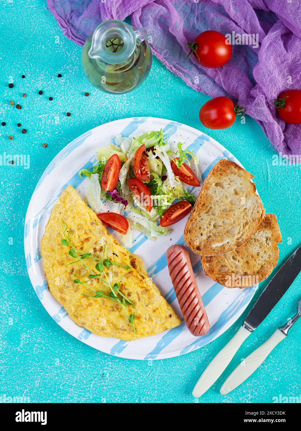 Gebratenes Omelette mit Wurst und Salat. Leckeres Frühstück mit Eiern und Toast Stockfoto