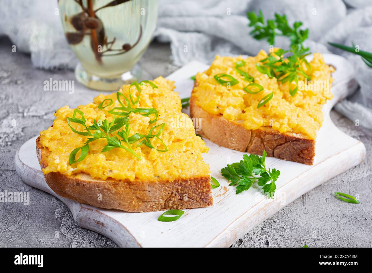 Rührei mit Kräutern und Toast. Leckeres Frühstück mit Eiern und Kräutern Stockfoto