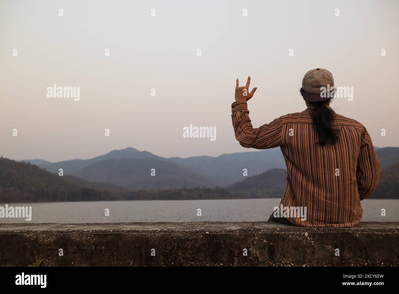 Der Mann benutzt Gebärdensprache Ich liebe dich, um seine Liebe und Freundschaft auszudrücken, seinen Freund und Geliebten. Gebärdensprache, die das Symbol „Ich liebe dich“ zeigt, um die Liebe f auszudrücken Stockfoto