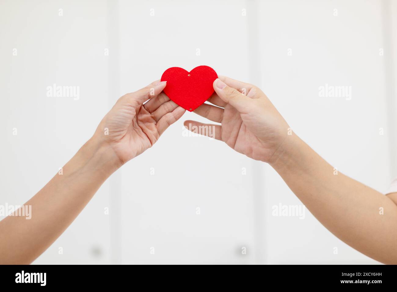 Paare zeigen zusammen herzförmige Symbole, um ihre Liebe und Freundschaft zueinander an ihrem großen Tag zu zeigen. Handgeformtes Herzsymbol für Ex Stockfoto