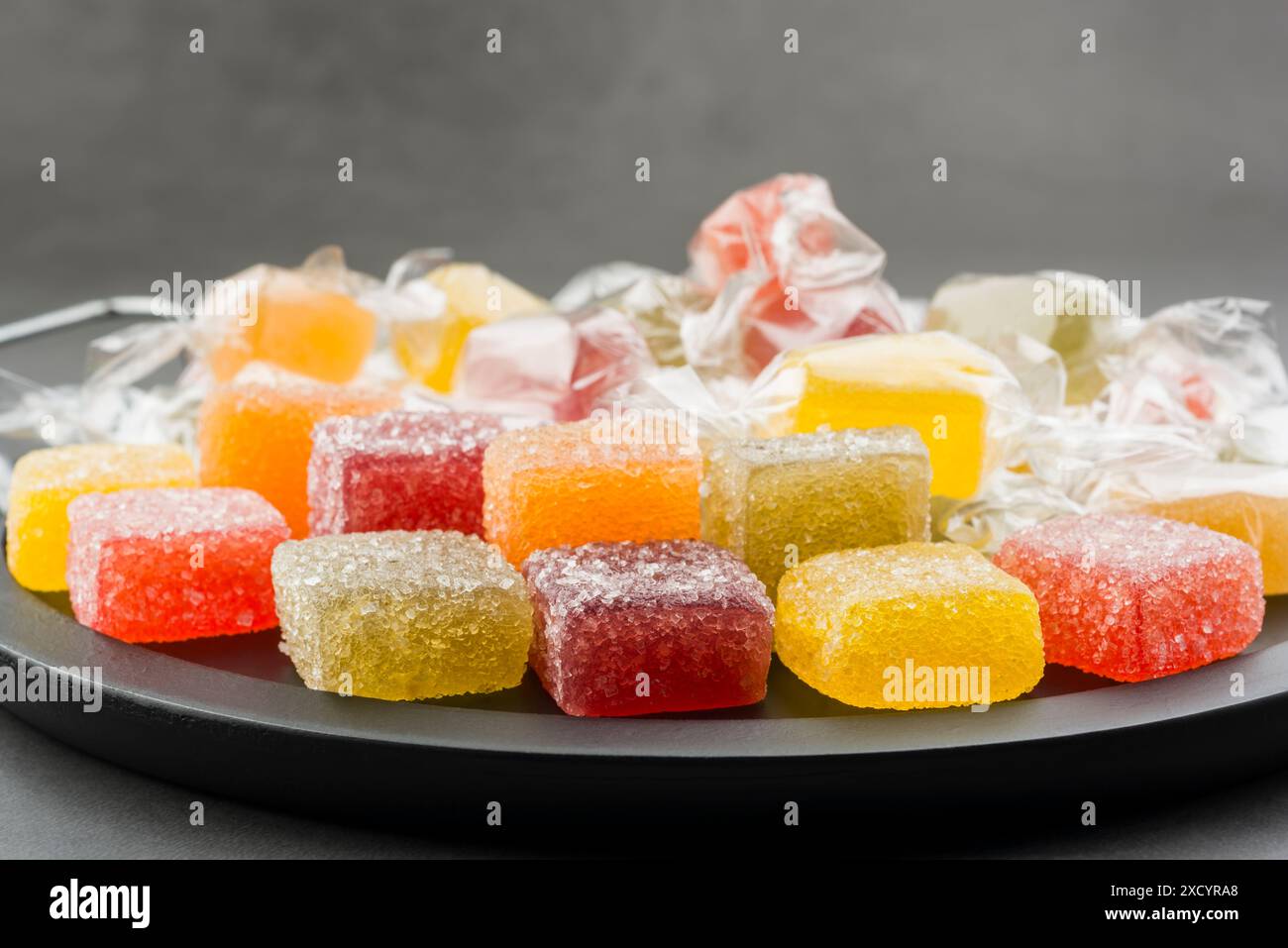 Verschiedene Gelee-Bonbons auf schwarzem Tablett. Stockfoto