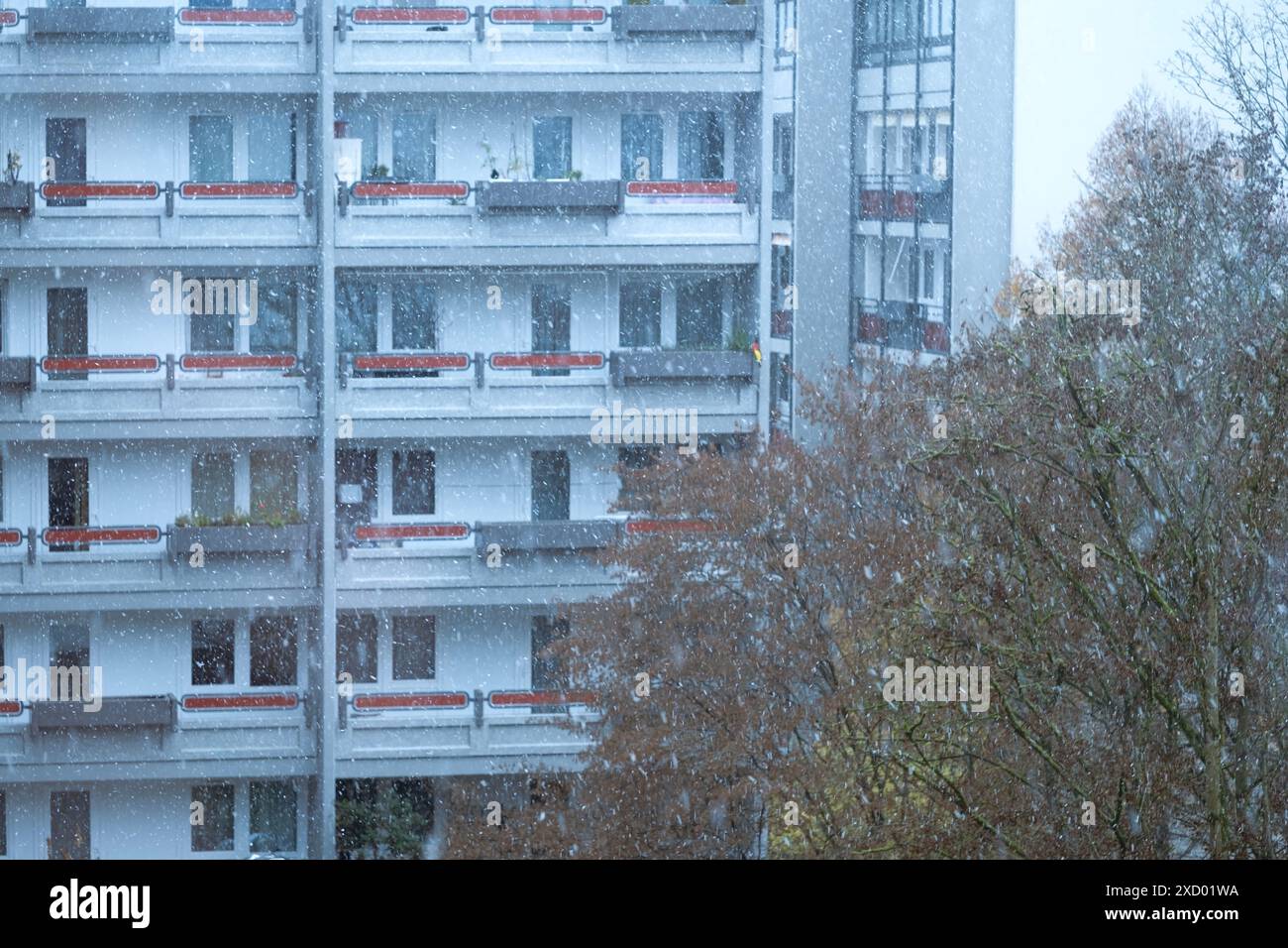 Schneit draußen vor dem Hintergrund eines mehrstöckigen Gebäudes, Stadtlandschaft, Winterwetter und Schneefall, Videoaufnahmen aus dem Raum, Stockfoto