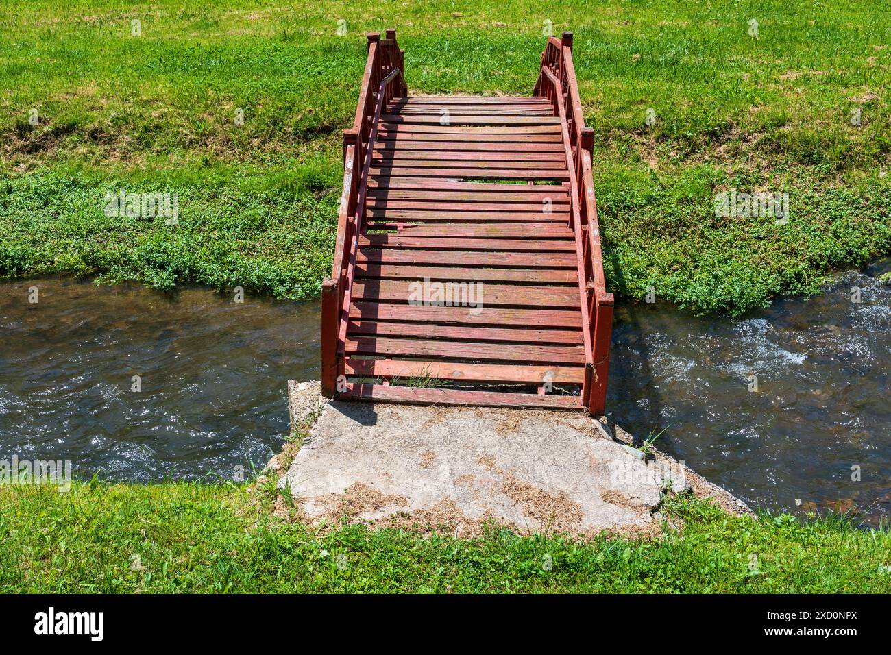 Rustikale Kreuzung. Wooden Brown Plank Bridge über den Fluss. Stockfoto