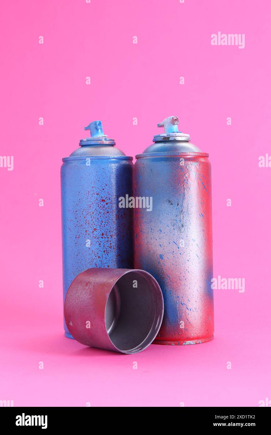 Sprühdosen mit Kappe auf rosafarbenem Hintergrund Stockfoto