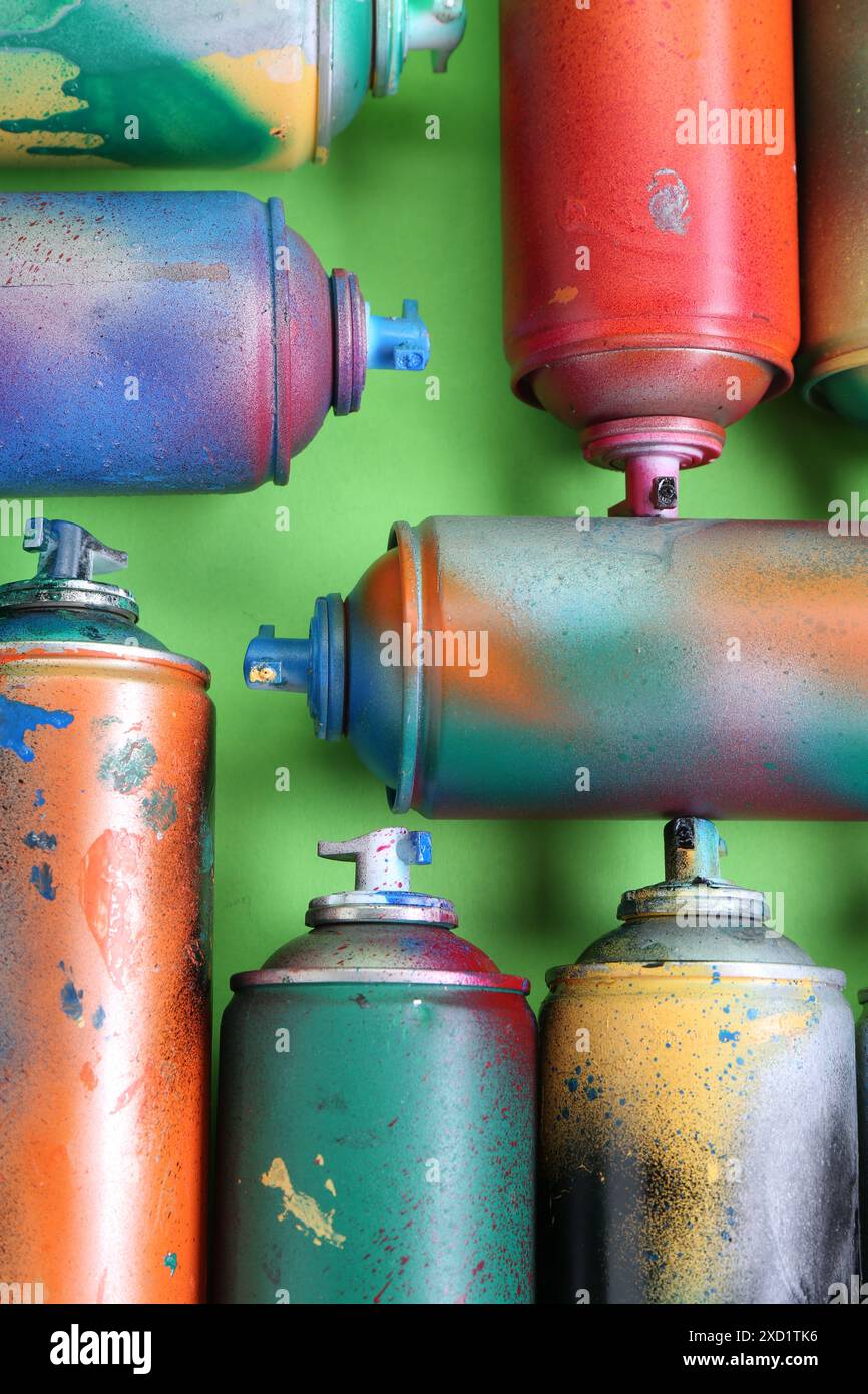 Viele Sprühdosen auf grünem Hintergrund, flach aufgelegt Stockfoto