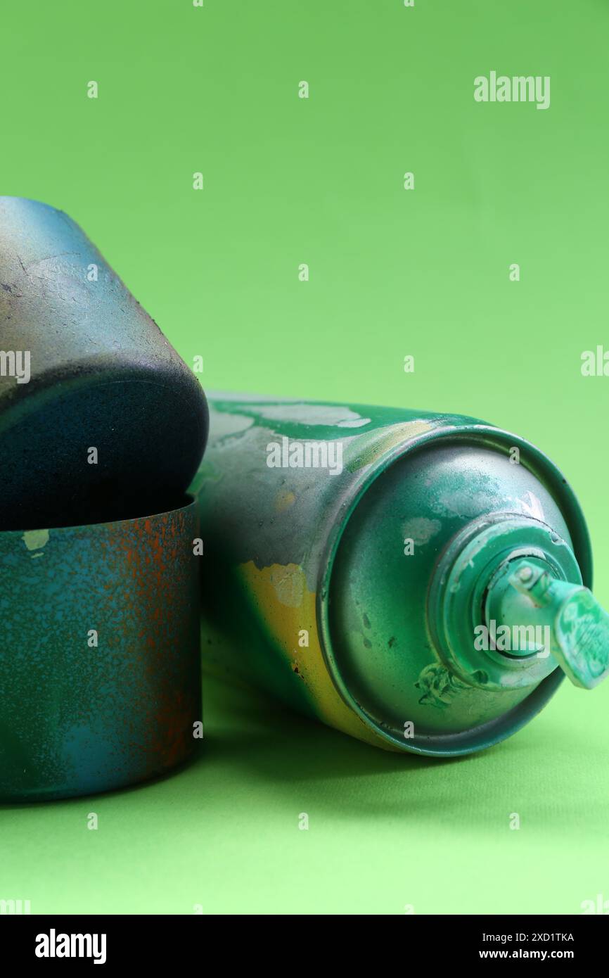 Sprühdose mit Kappen auf grünem Hintergrund, Nahaufnahme Stockfoto