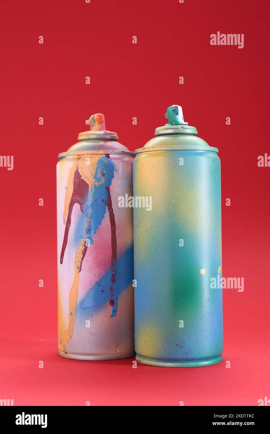 Zwei Sprühdosen auf rotem Hintergrund Stockfoto