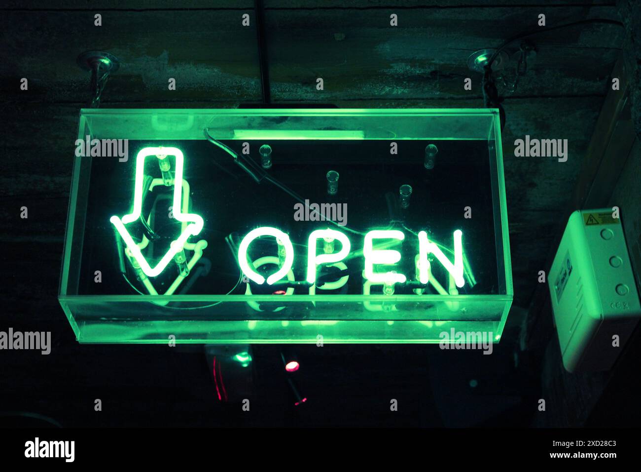 Ein grün leuchtendes Neonschild zeigt an, dass die Leiste geöffnet ist. Stockfoto