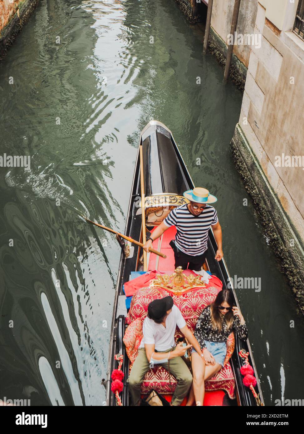 Venedig, Italien - 20. Juni 2021 Gondoliere führt durch einen schmalen Kanal in venedig und bietet Touristen eine herrliche Gondelfahrt Stockfoto