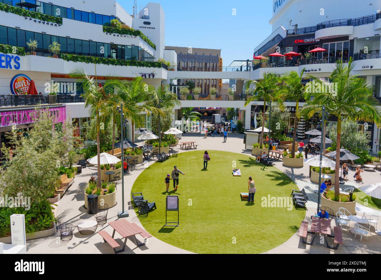 Los Angeles, Kalifornien - 10. April 2024: Zentraler Innenhof in der FIGat7th Mall, in dem die Menschen auf dem Grasgelände spazieren gehen, umgeben von Geschäften und Restaurants Stockfoto