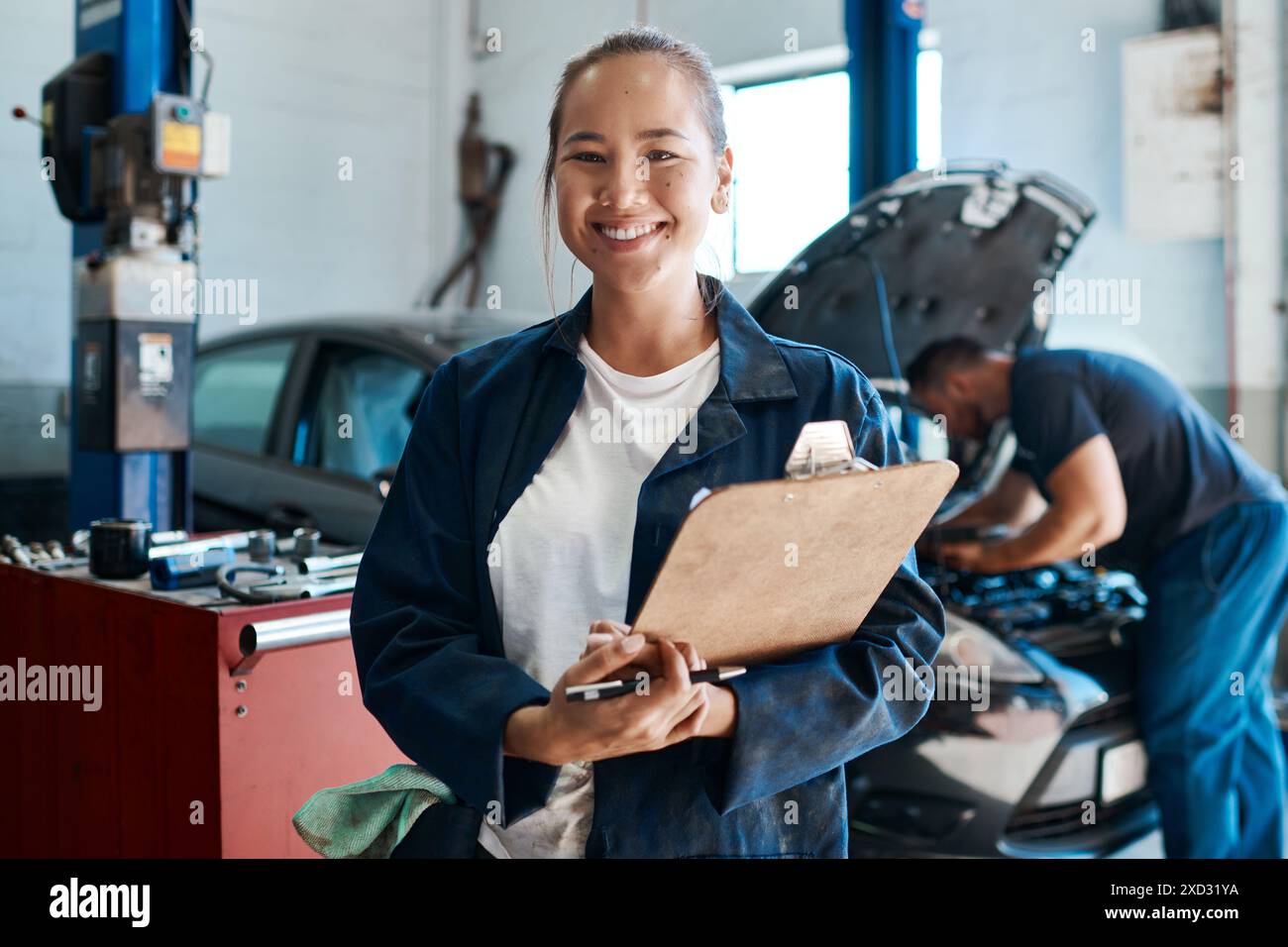 Frau, Porträt und Klemmbrett im Auto für mechanische Wartung, Service und Sicherheitsüberprüfung in der Werkstatt. Asiatischer Ingenieur oder Arbeiter mit Checkliste Stockfoto