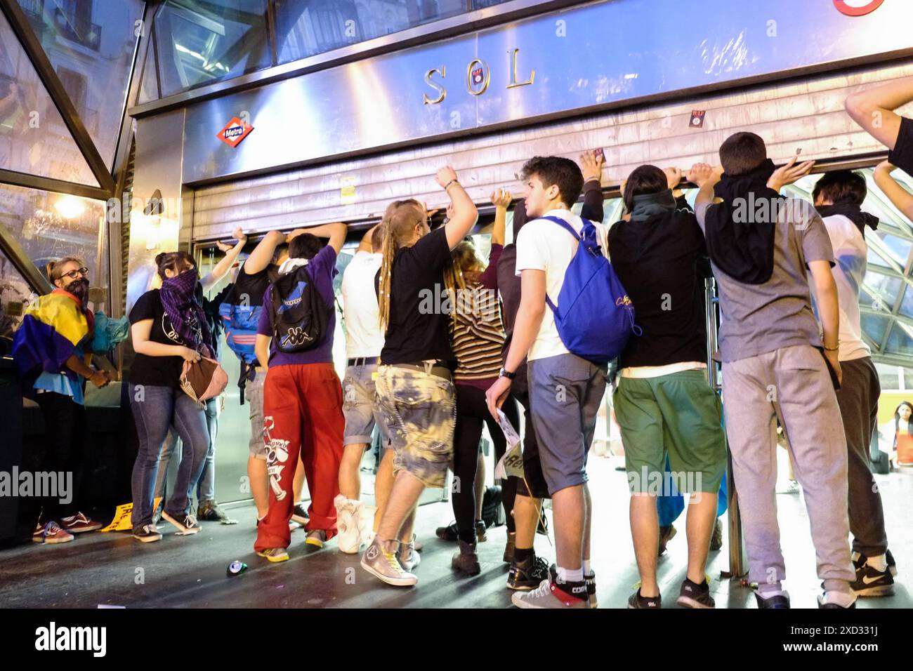 Anti-Monarchie-Demonstranten in Puerta del Sol Madrid halten das Tor zur U-Bahn-Haltestelle Sol hoch, damit weitere Demonstranten hereinkommen können. Kurz bevor Hunderte von Demonstranten aufgetaucht waren, als Reaktion auf die Ankündigung der Abdankung von König Juan Carlos. Stockfoto