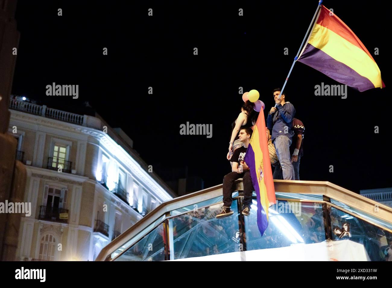 Anti-Monarchie-Demonstranten sitzen auf der Sol Metro in Madrid und schwenken die Flagge der Zweiten Spanischen Republik nach der Ankündigung der Abdankung von König Juan Carlos I. Stockfoto