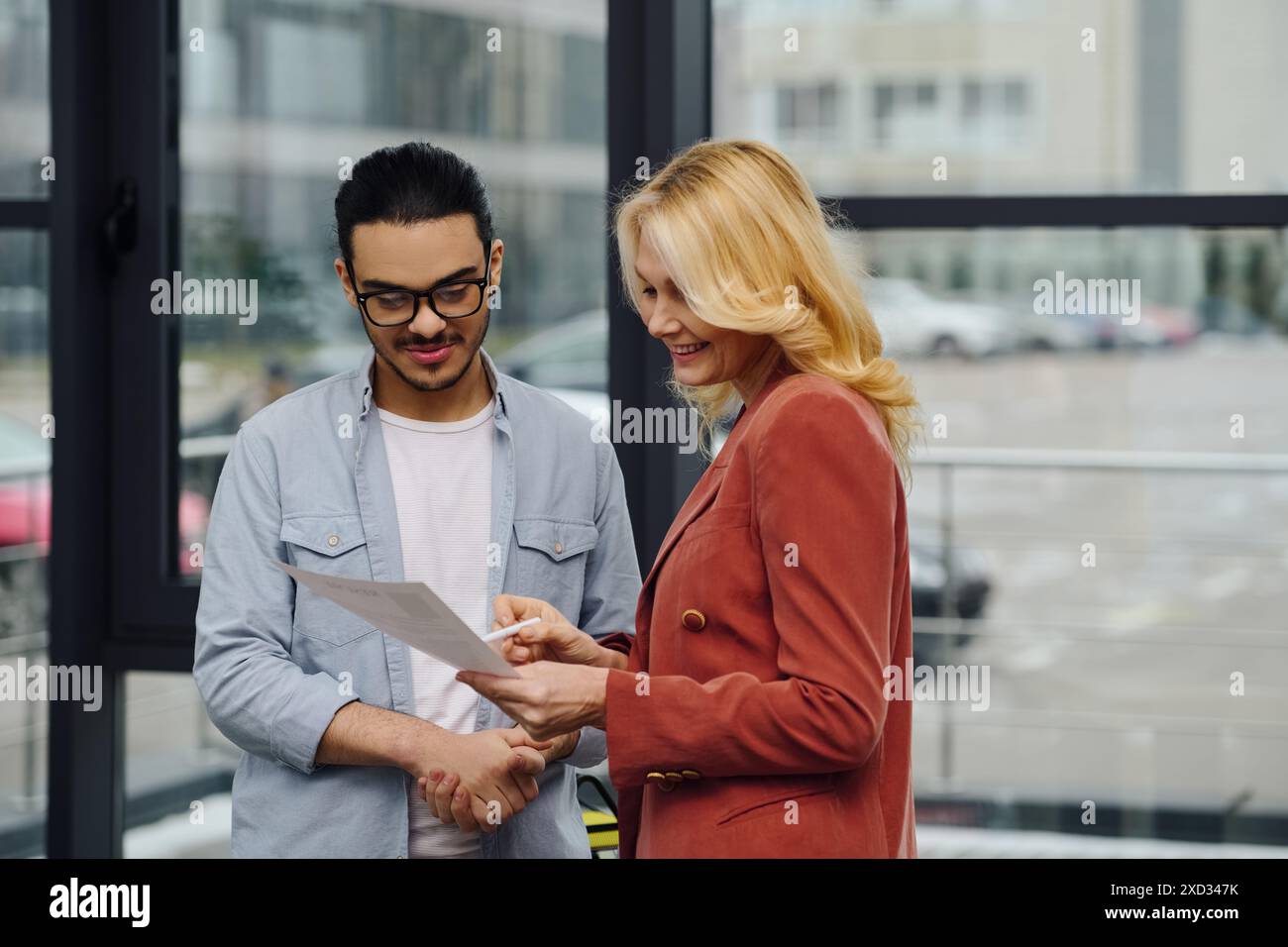 Zwei Personen führen ein Gespräch vor einem Bürogebäude. Stockfoto