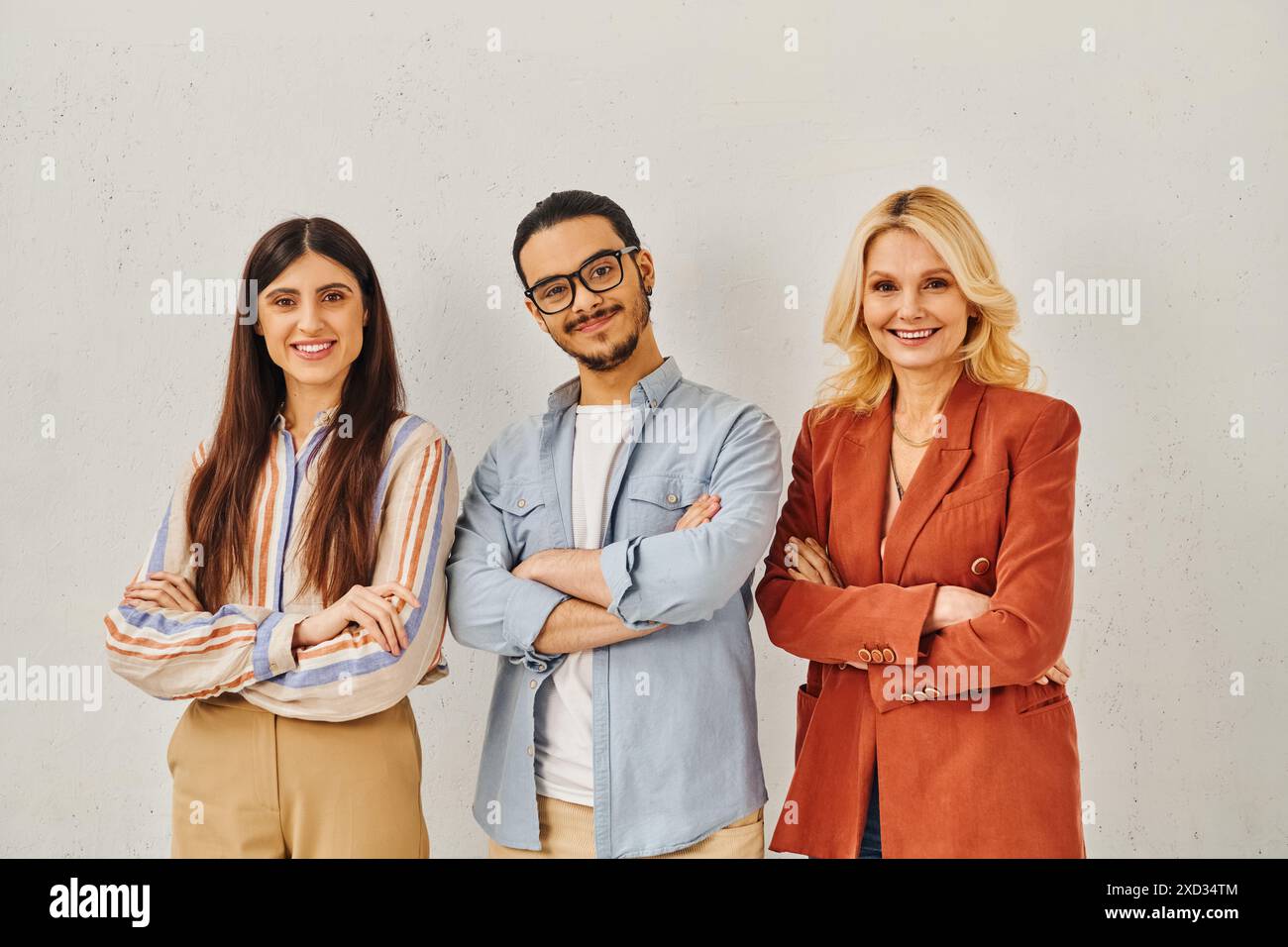 Drei Profis posieren selbstbewusst vor weißem Hintergrund. Stockfoto