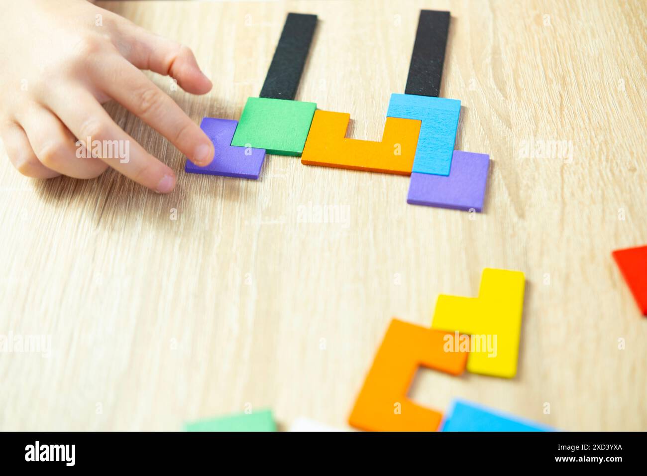 Intelligentes Kind löst Probleme, manipuliert bunte hölzerne geometrische Stücke intellektuelles Puzzle, kognitives Wachstum, Gehirn Teaser, Denkfähigkeiten Stockfoto