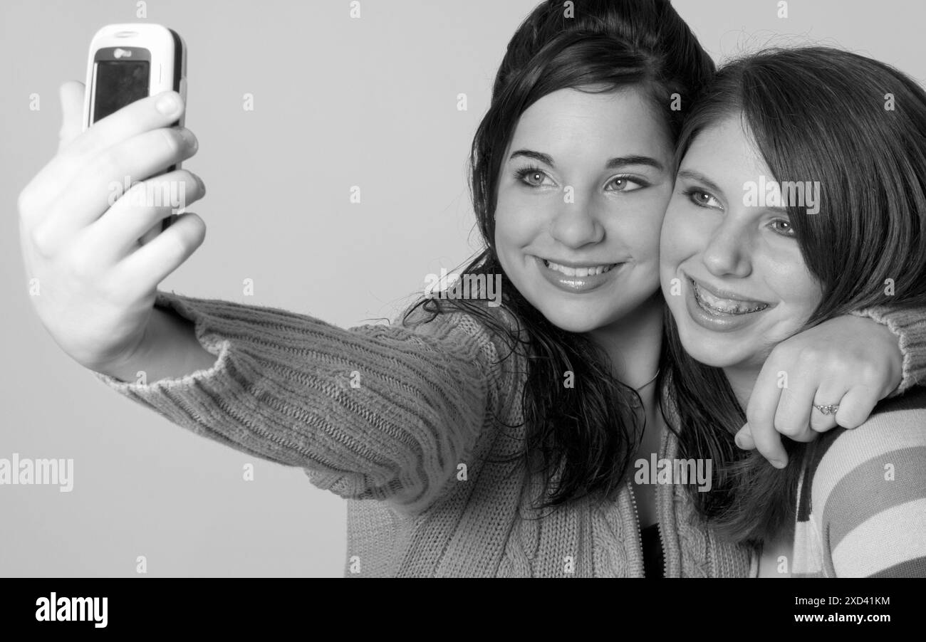 Zwei kaukasische Teenager-Freundinnen machen ein Selfie mit einem Smartphone in den USA. Stockfoto