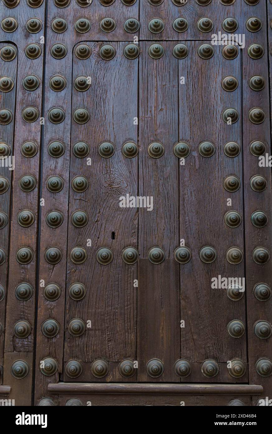Alte, rissige Holztür mit rostigen Metallnieten am Eingang eines Tempels Stockfoto