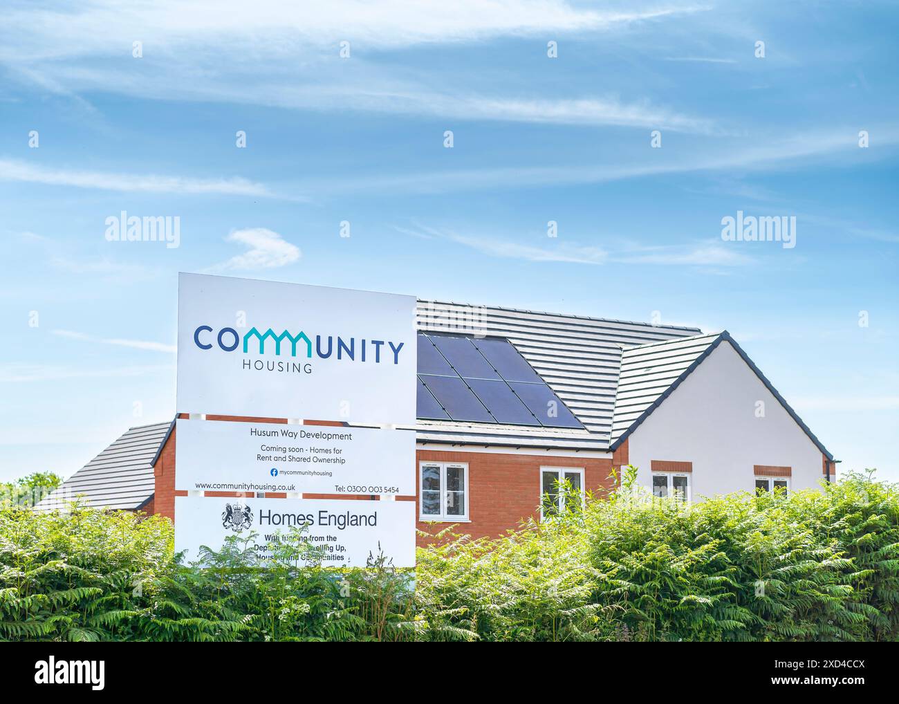 Großes Schild/Schild für „Community Housing“ von New Build Houses, Großbritannien, unterstützt von der Regierungsbehörde Homes England, die erschwingliche, hochwertige Häuser anbietet. Stockfoto